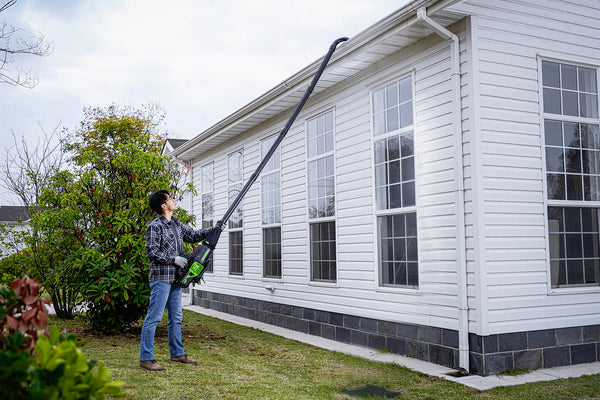 Person cleaning gutters with Greenworks leaf blower