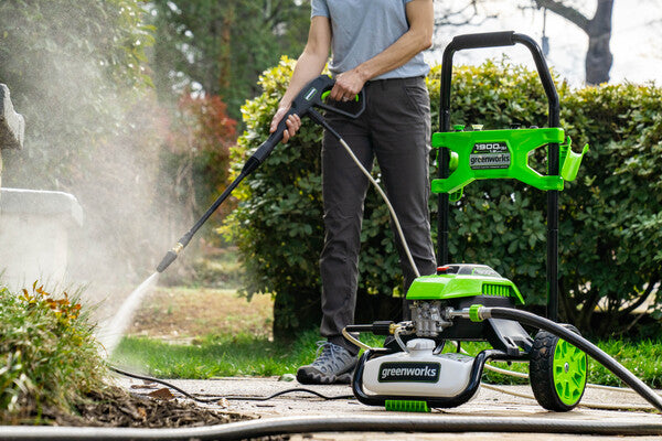 A Greenworks pressure washer cleaning concrete.